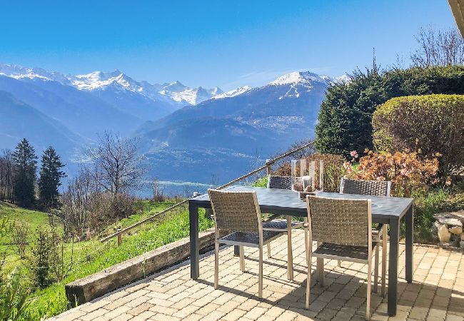 Die Terrasse mit Gartenmöbeln bietet einen herrlichen Blick auf die Berge.