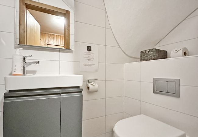 Funktionelles, eingerichtetes WC im Erdgeschoss, ausgestattet mit Waschbecken und Spiegel