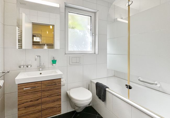 Blick in das Badezimmer, das mit einer Badewanne, einer Toilette und einem Waschbecken ausgestattet ist