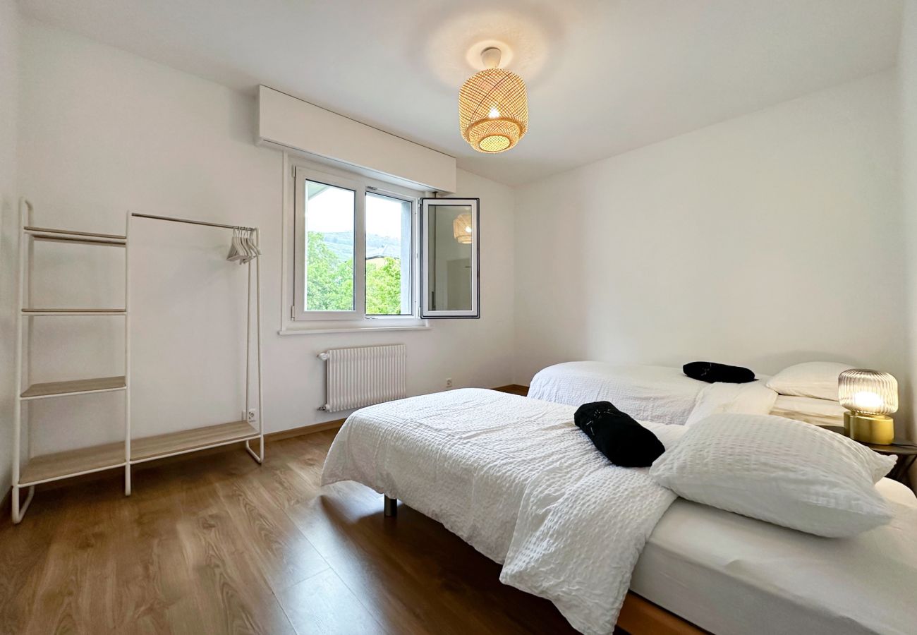 Warmes Zimmer mit zwei Einzelbetten und einem Fenster, das den Raum erhellt