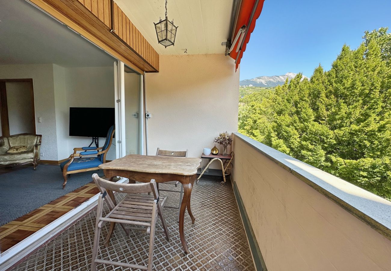 Blick vom Balkon durch die große Fensterfront auf den Wohnraum
