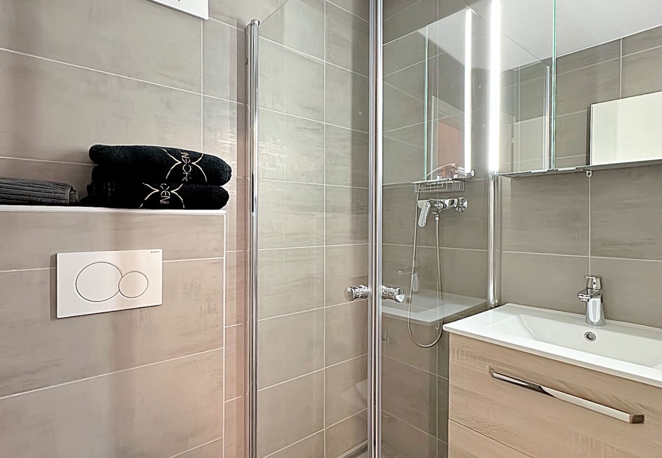 Praktisches Badezimmer mit verglaster Dusche, WC und Waschbecken