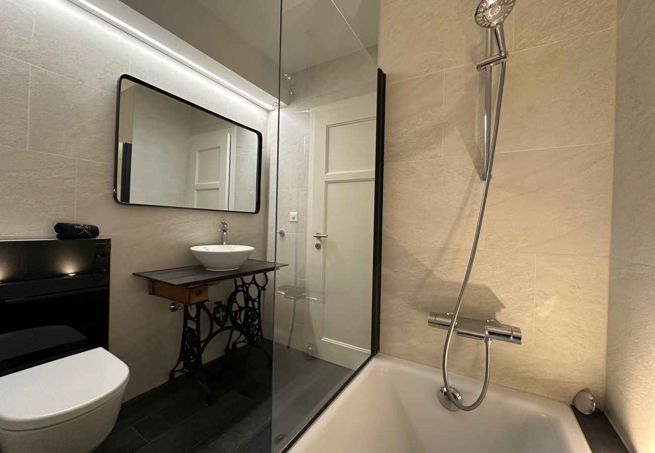 A shower room with convenient washbasin, WC, large mirror and comfortable bathtub