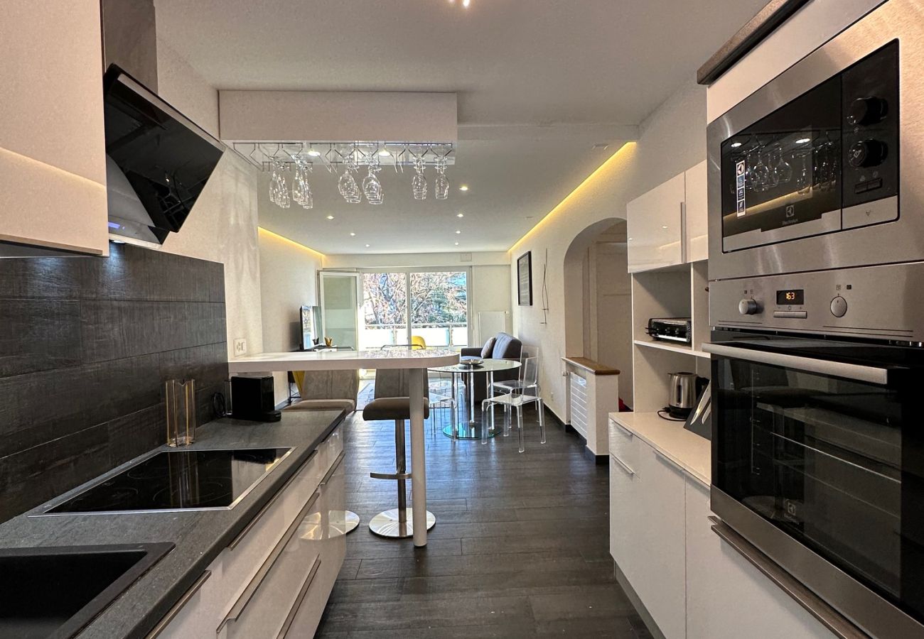 View of the modern, fully-equipped kitchen opening onto the living room with a bar counter