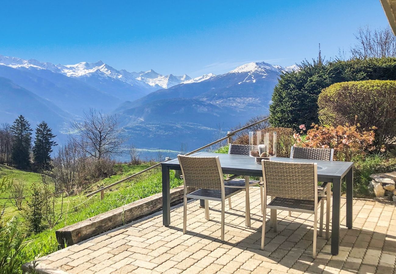La terrasse, avec ses meubles de jardin, offre une vue magnifique sur les montagnes