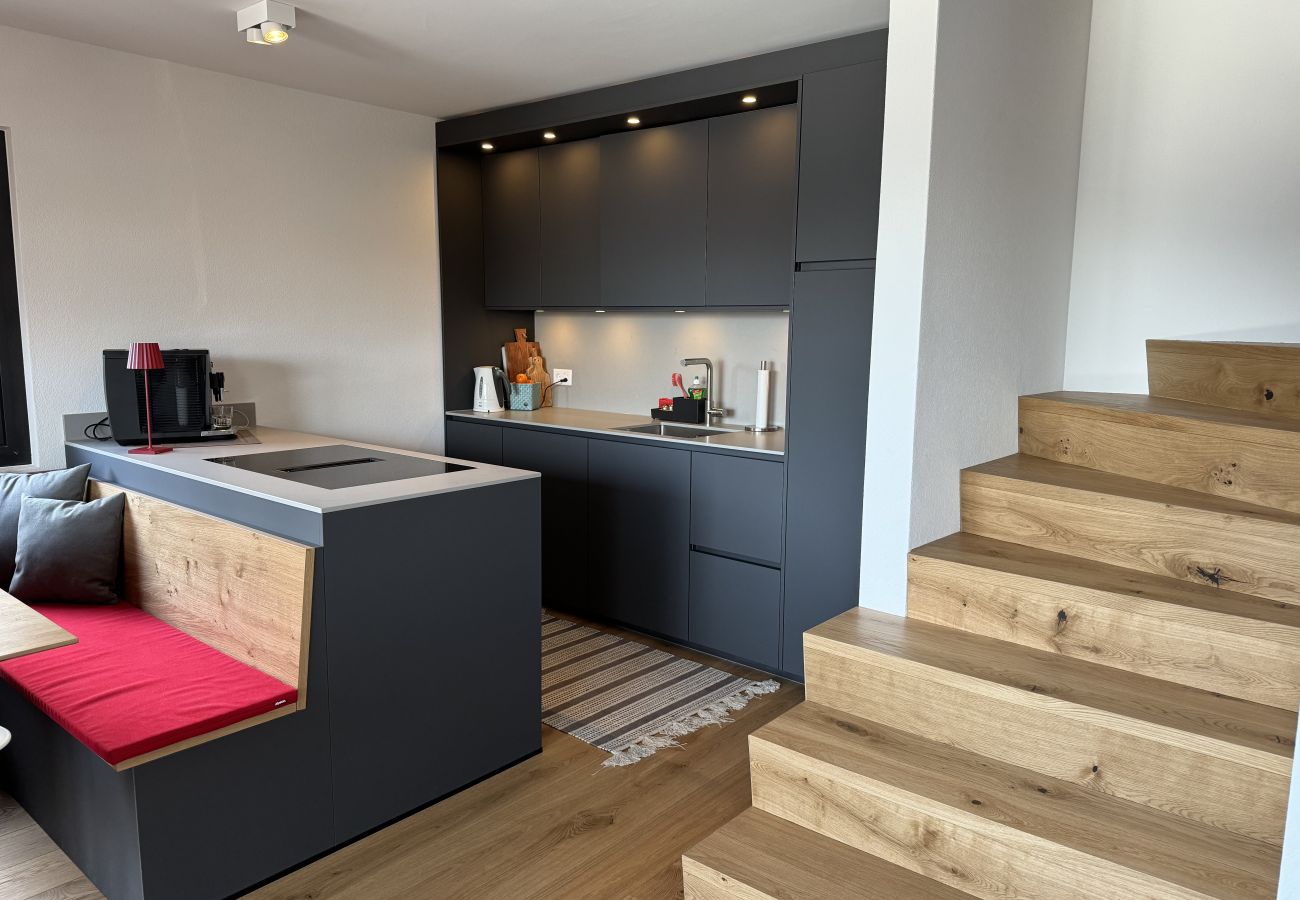 Cuisine entièrement pourvue en équipements, prête à l'emploi, avec une vue sur l'escalier menant à l'étage