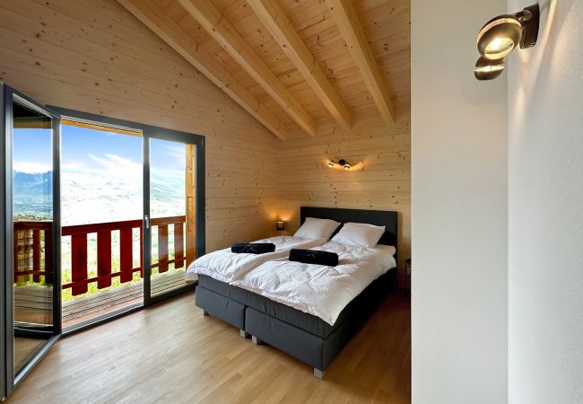 Chambre avec lit Queen Size chaleureuse et spacieuse avec une vue magnifique depuis la fenêtre