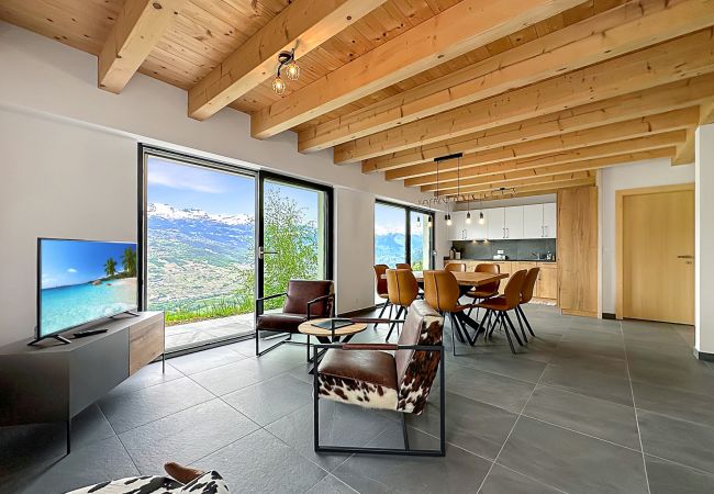 Salon avec vue spectaculaire et tv, ouvert sur salle à manger spacieuse et lumineuse