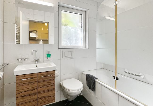 Vue de la salle de bain fonctionnelle et spacieuse, équipée d'une baignoire, d'un WC et d'un lavabo