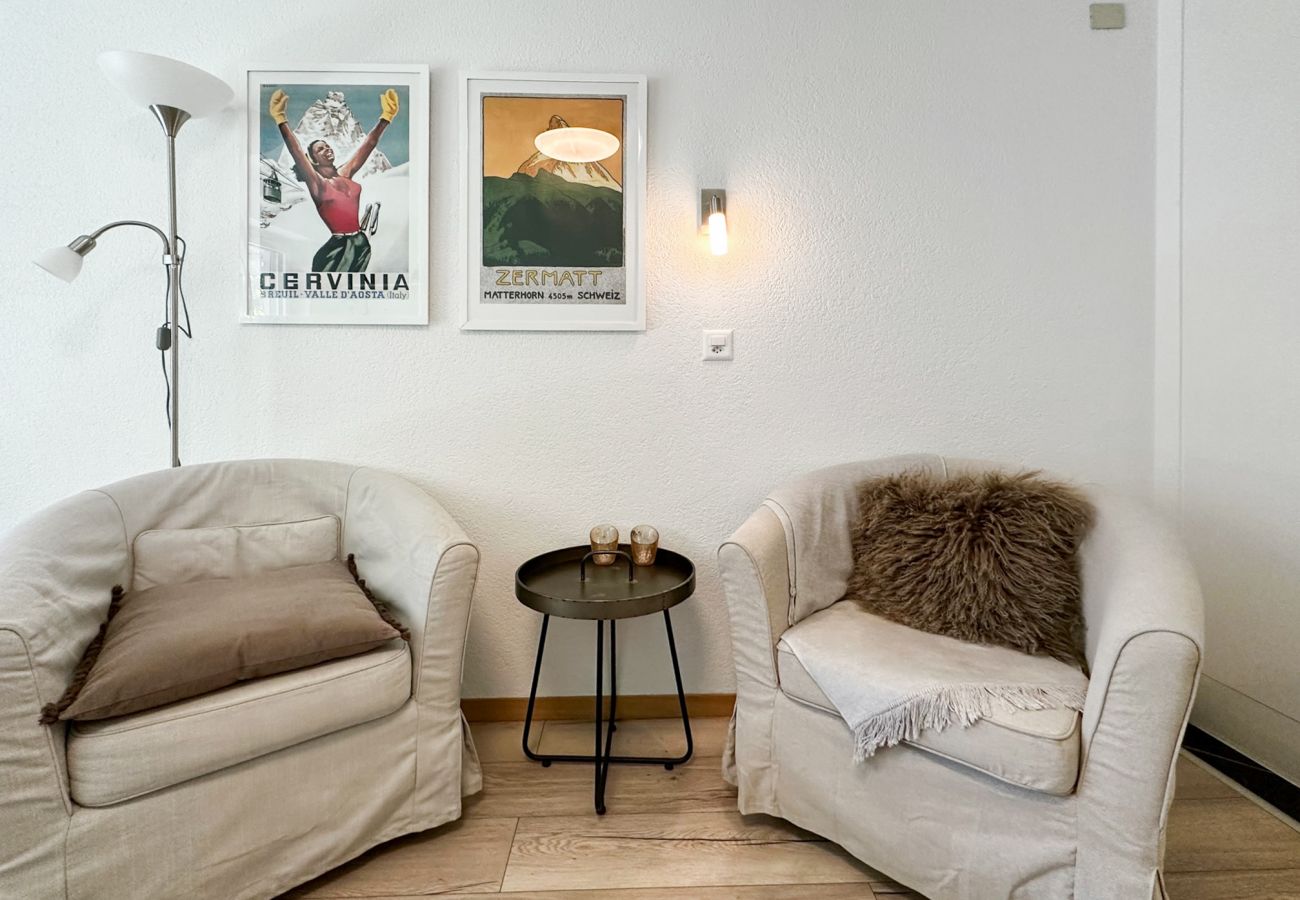 Deux fauteuils confortables avec une petite table, parfait pour déguster un café