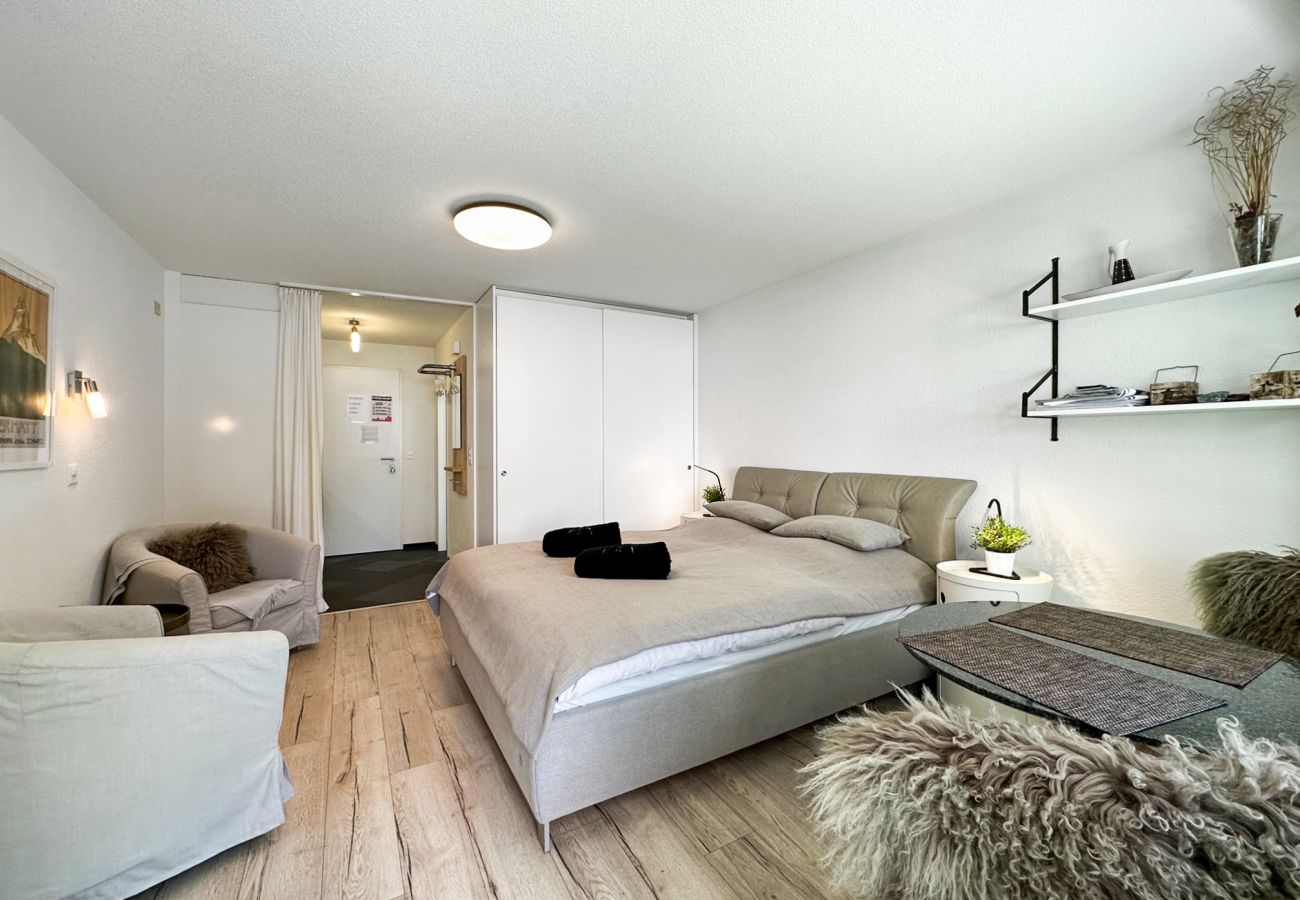 Découvrez un studio aéré offrant une vue sur la porte d'entrée et un lit double confortable