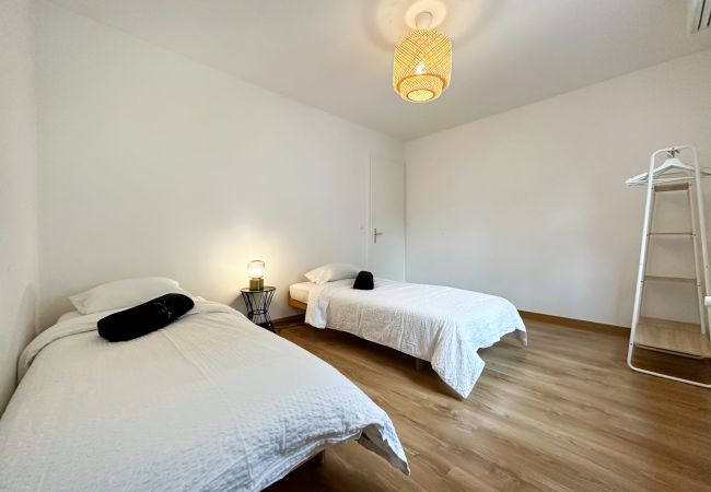 Chambre douillette avec deux lits simples et une fenêtre pour une atmosphère chaleureuse