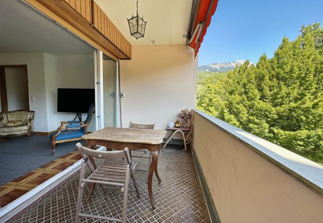 Vue depuis le balcon sur la pièce à vivre à travers la grande baie vitrée