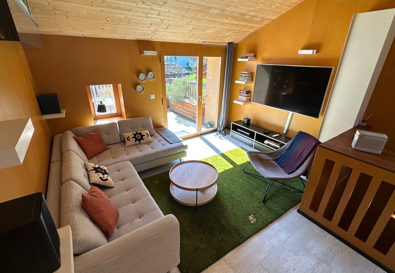 Pièce à vivre avec canapé et accès au balcon pour une vue imprenable