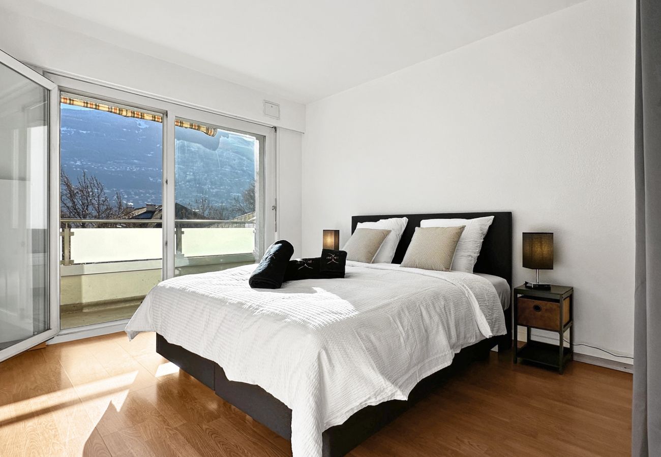 Chambre avec un lit queen size avec une grande porte fenêtre